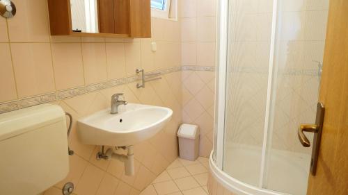 W łazience znajduje się umywalka i prysznic. w obiekcie Villa Dvorine w mieście Tisno