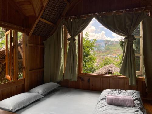 a bed in a room with a large window at Đà Lạt Củi Homestay in Da Lat