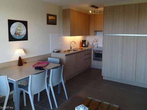 une cuisine avec une table et des chaises et une cuisine avec un évier dans l'établissement Rez-de-chaussée avec terrasse, parking, animaux acceptés près de la mer - FR-1-675-15, à Wimereux