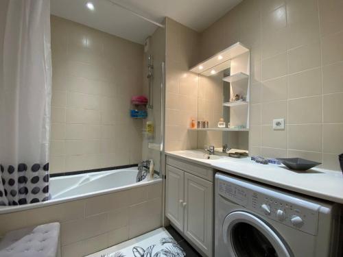 W łazience znajduje się pralka i wanna. w obiekcie Appartement spacieux face plage avec balcon, parking privé et animaux admis à Trégastel - FR-1-368-378 w mieście Trégastel