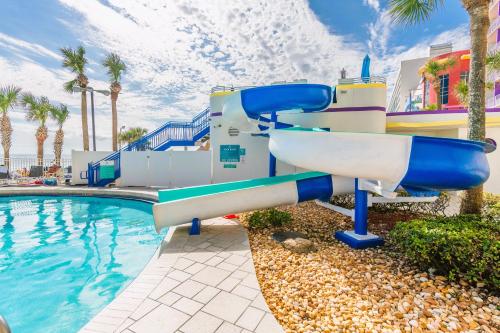un tobogán de agua junto a una piscina en un complejo en Vitamin Sea - Modern Beach Highrise At Ocean Walk Resort Daytona Beach, en Daytona Beach