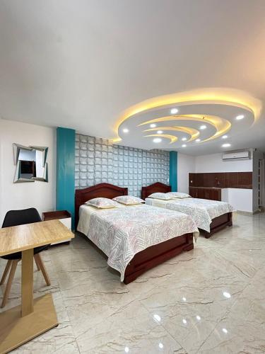 1 dormitorio con 2 camas y techo circular en Hotel Monaco, en Santo Domingo de los Colorados