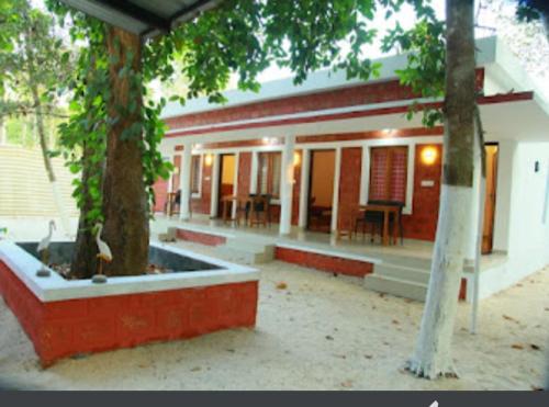 a house with a tree in front of it at Agape Marari in Mararikulam