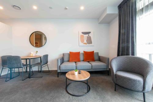 a living room with a couch and chairs and a table at Deluxe One Bedroom Apartment in Newmarket Auckland in Auckland