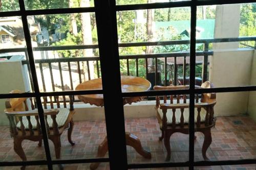 a balcony with a table and chairs on a porch at Charming Getaway @ The City of Pines in Baguio