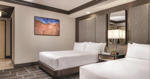 um quarto de hotel com duas camas e um espelho em Strip Las Vegas Unit by Luxor and T Mobile arena area em Las Vegas