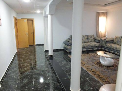 a living room with white columns and a couch at Hotel El Medina in Nouadhibou