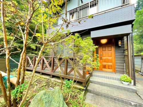 a small house with a wooden door and stairs at 飯能テラス in Hanno