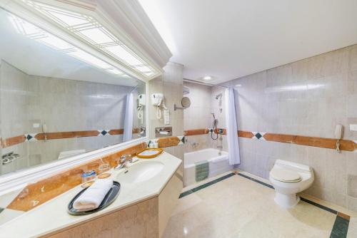 a bathroom with a sink and a toilet at Hotel Silverland in Dongguan