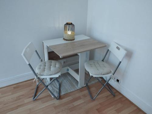 d'une petite table avec deux chaises et une lampe. dans l'établissement Parisian Vibes à Clichy, à Clichy
