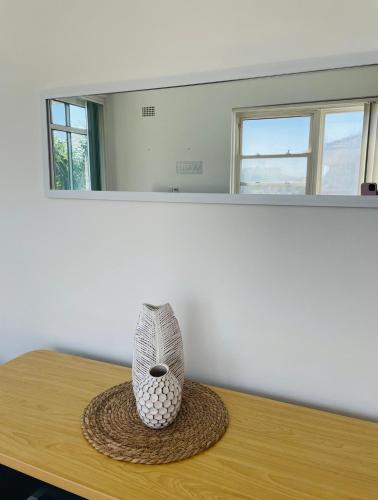 a vase sitting on a table in a room at Eloura Gardens 100m to Beach in Cronulla