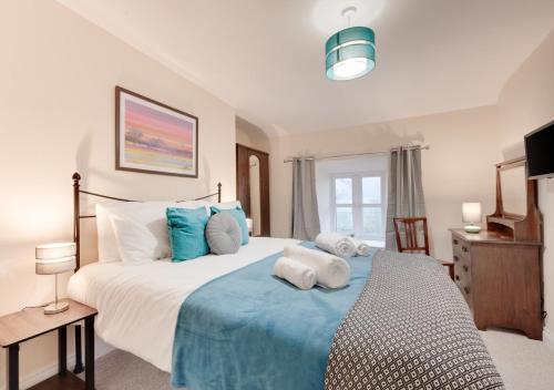 a bedroom with a large bed with blue and white pillows at Pwllglas in Darowen