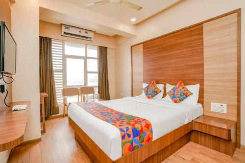 a hotel room with a bed and a television at Hotel Mahadev Residency - Dapode, Bhiwandi in Kolshet