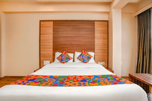 a bedroom with a large bed with a wooden headboard at Hotel Mahadev Residency - Dapode, Bhiwandi in Kolshet