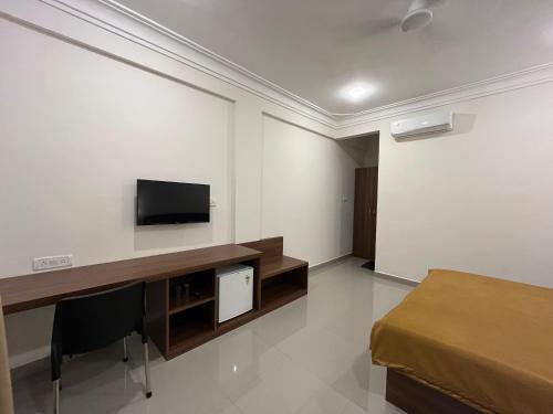 a room with a flat screen tv on a wall at Morjim Sunset Guesthouse- Apartments with Kitchen & AC Rooms in Morjim
