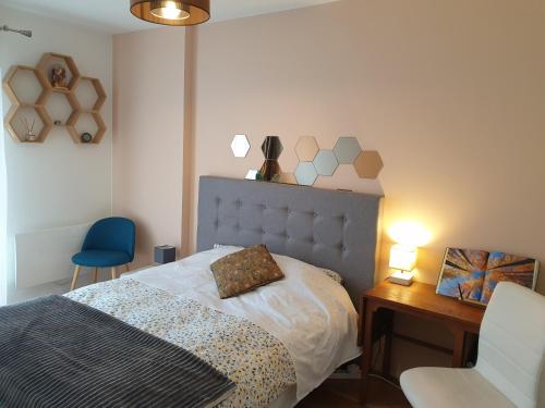 a bedroom with a bed and a desk and a chair at Appartement spacieux Paris St Denis Stade de France in Saint-Denis