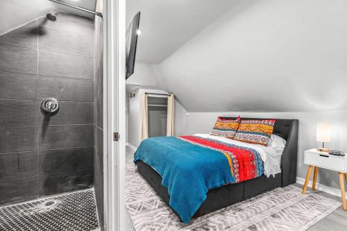 um pequeno quarto com uma cama e um chuveiro em 3rd Story Loft next to West Village Free Parking em Detroit