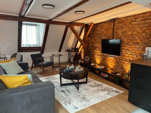 a living room with a couch and a tv on a brick wall at Grich Witch apartment in Zagreb