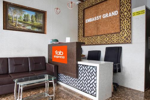 a lobby with a couch and a desk with a sign at FabExpress Embassy Grand in Mumbai