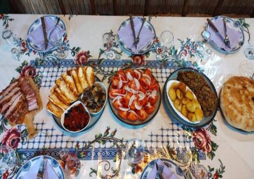 a table topped with plates and bowls of food at Rajacke pivnice Country House C`est La Vie in Rajac