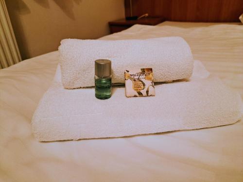 a pile of towels and a bottle on a bed at Hasičský hotel Přibyslav in Přibyslav