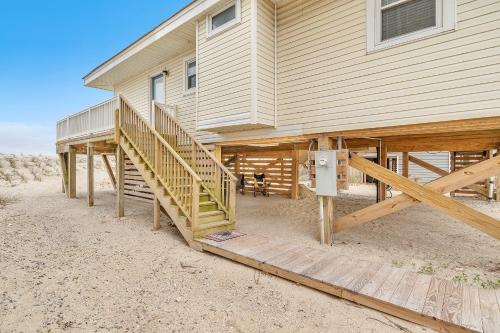 a house with wooden stairs leading up to it at Lisa Lu by Oak Island Accommodations in Oak Island