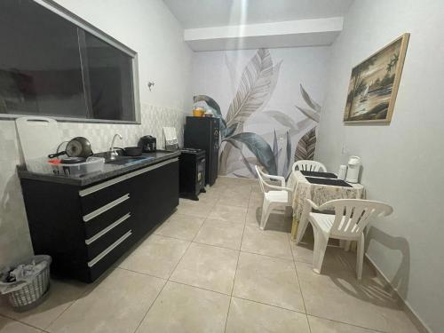 cocina con fregadero, mesa y sillas en Flat hotel Victoram, en Rio Branco