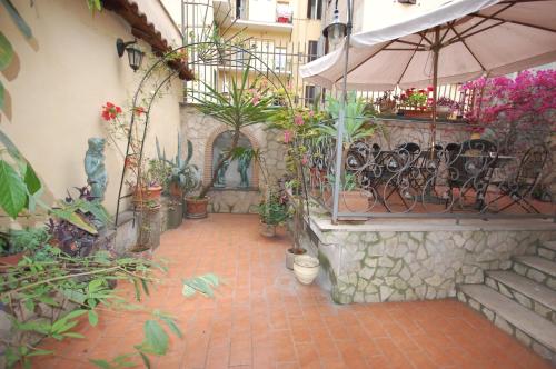 ローマにあるホテル アレクシスの植物と傘が並ぶ中庭