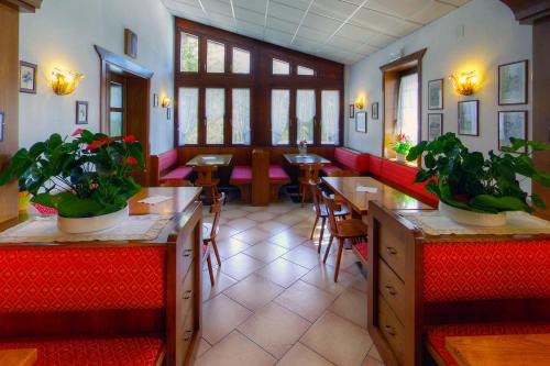 a restaurant with tables and chairs and potted plants at GH Hotel Fratazza in San Martino di Castrozza