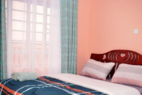 1 dormitorio con cama y ventana en Nova Homes, en Thika