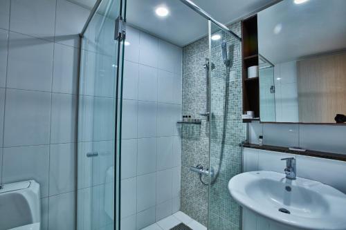 y baño con ducha acristalada y lavamanos. en Provista Hotel en Seúl