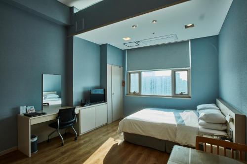 Provista Hotel في سول: غرفة نوم بسرير ومكتب وتلفزيون
