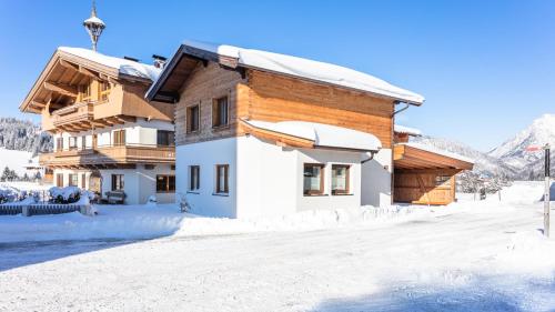 ein Haus im Winter mit Schnee auf dem Boden in der Unterkunft Ferienwohnungen Recherhof in Hochfilzen