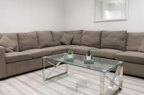 a living room with a couch and a glass coffee table at 5 Bed Town House Within City Centre and Sleeps Up To 11 with Sky and Netflix in Birmingham