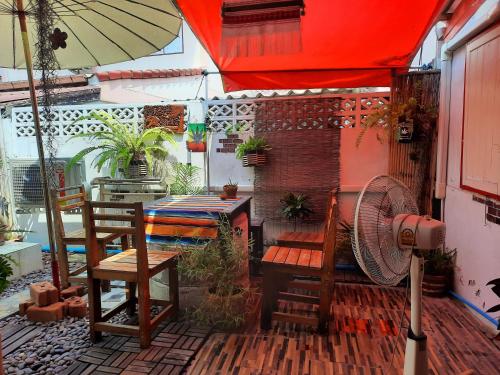 d'une terrasse avec des chaises, un parasol et un ventilateur. dans l'établissement ThaiMex Cafe & Homestay Backpackers- Adults Only, à Prachuap Khiri Khan