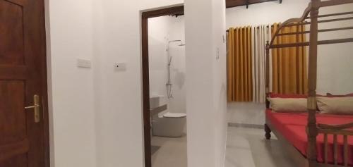 a bathroom with a bed and a shower in a room at Lanka Villas Holiday Resort in Kandy