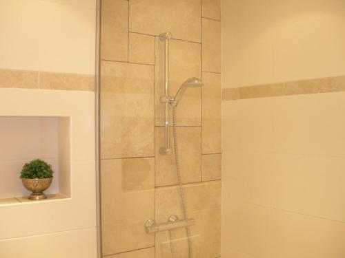 een douche met een glazen deur in de badkamer bij Pension Kamperland in Kamperland