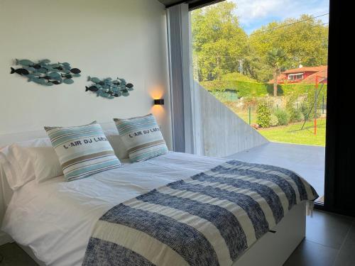 a bedroom with a bed with a large window at La Casa de Hierba - Casa de campo de diseño con jardín y wifi cerca de las playas de Llanes in Llanes