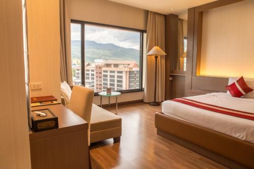 a hotel room with a bed and a large window at Chiangmai Grandview Hotel & Convention Center in Chiang Mai