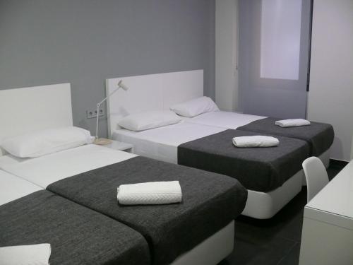 two beds in a small room with towels on them at HOSTAL LETTO DAL MARE in Valencia