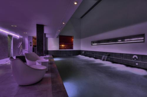 a bathroom with a tub and a sink with purple lighting at Kimpton - Blythswood Square Hotel, an IHG Hotel in Glasgow