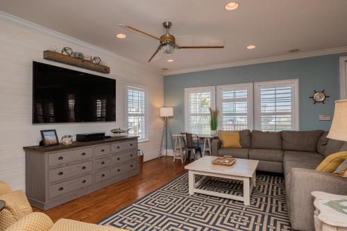 a living room with a couch and a tv at The Anchor Holds by Oak Island Accommodations in Oak Island