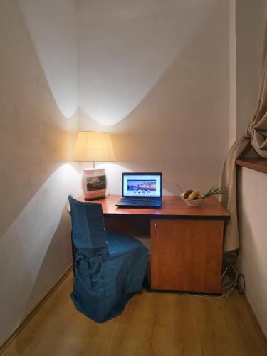 a desk with a laptop and a lamp on it at Hotel City Pisek in Písek