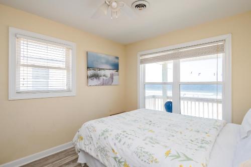 a bedroom with a bed and a large window at Absolute Beach by Oak Island Accommodations in Oak Island
