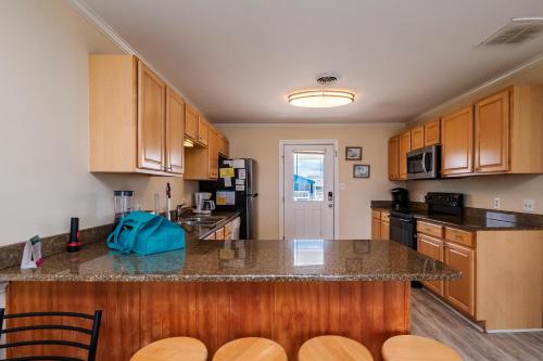 a kitchen with wooden cabinets and a counter top at Absolute Beach by Oak Island Accommodations in Oak Island