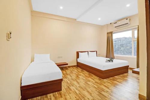 a hotel room with two beds and a window at Sri Udupi park phoenix mall in Bangalore