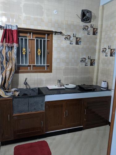 cocina con fregadero y ventana en Shri Sai Apartment AC, en Mettuppālaiyam