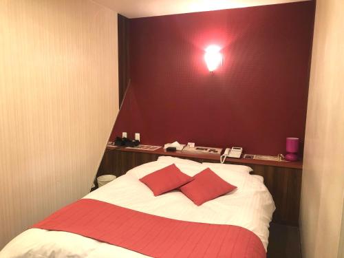 a bedroom with a bed with red pillows on it at 尾道ラブラス in Onomichi