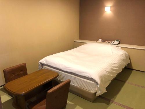 a small hospital room with a bed and a table at 尾道ラブラス in Onomichi