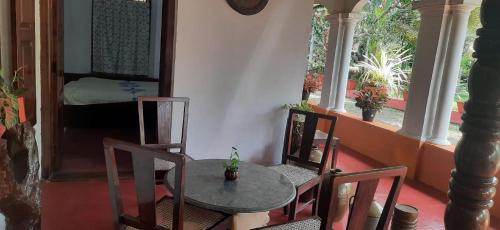 a table and chairs in a room with a bedroom at Kallupurackal Heritage Island Home By Lexstays in Alleppey